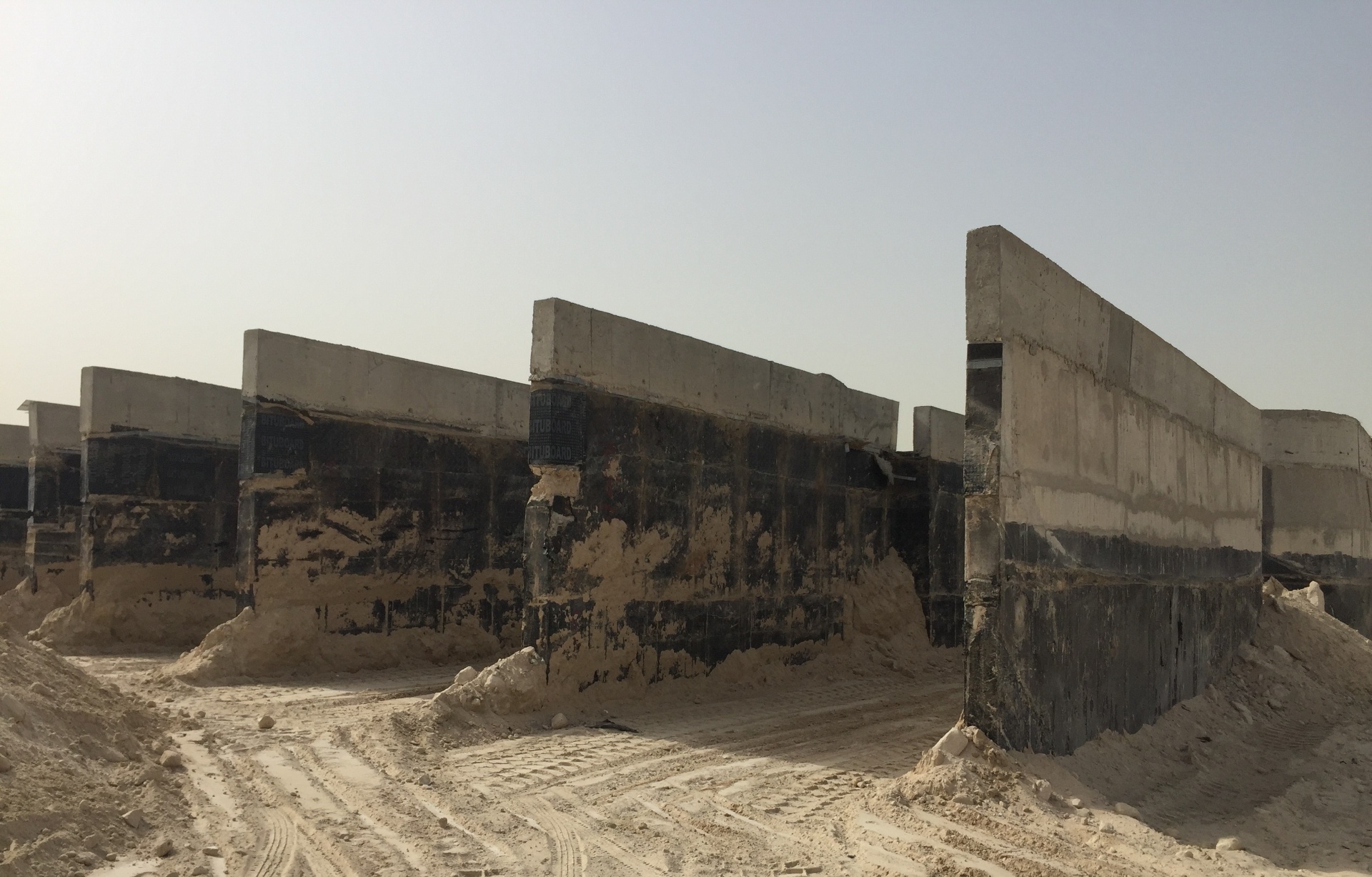 Concrete foundation walls with waterproof membrane exposed