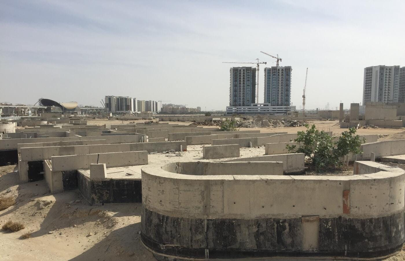 Panoramic view of 28 buildings foundation site with Dubai skyline