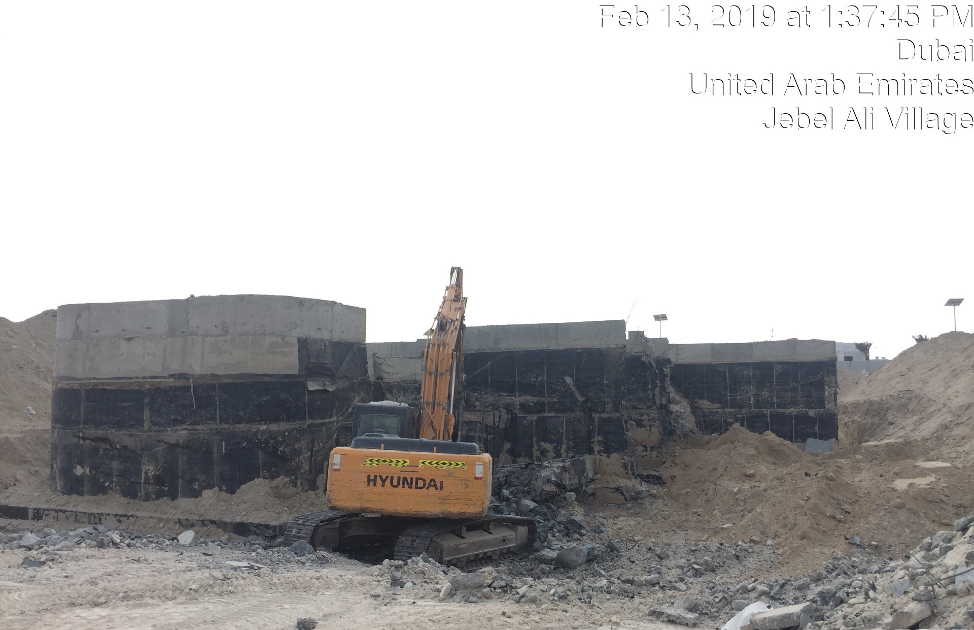 Hyundai excavator demolishing foundation walls at Jebel Ali Village