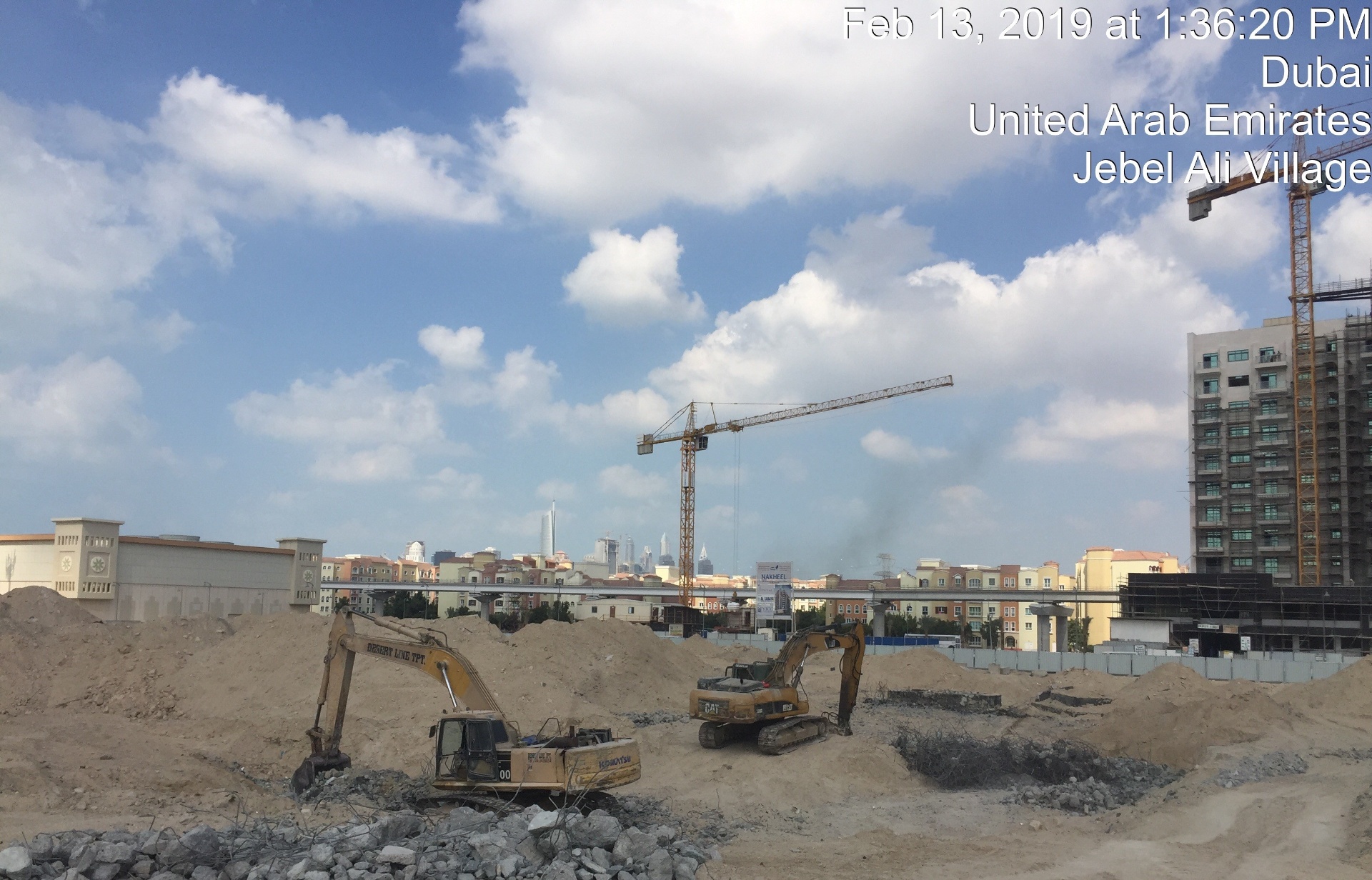 CAT excavators demolishing foundations with Dubai skyline