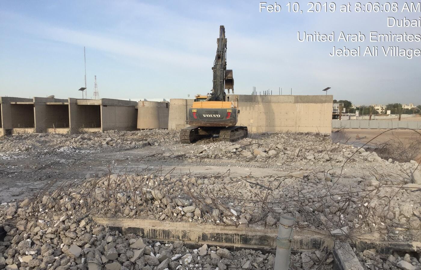 Volvo excavator breaking concrete foundation walls