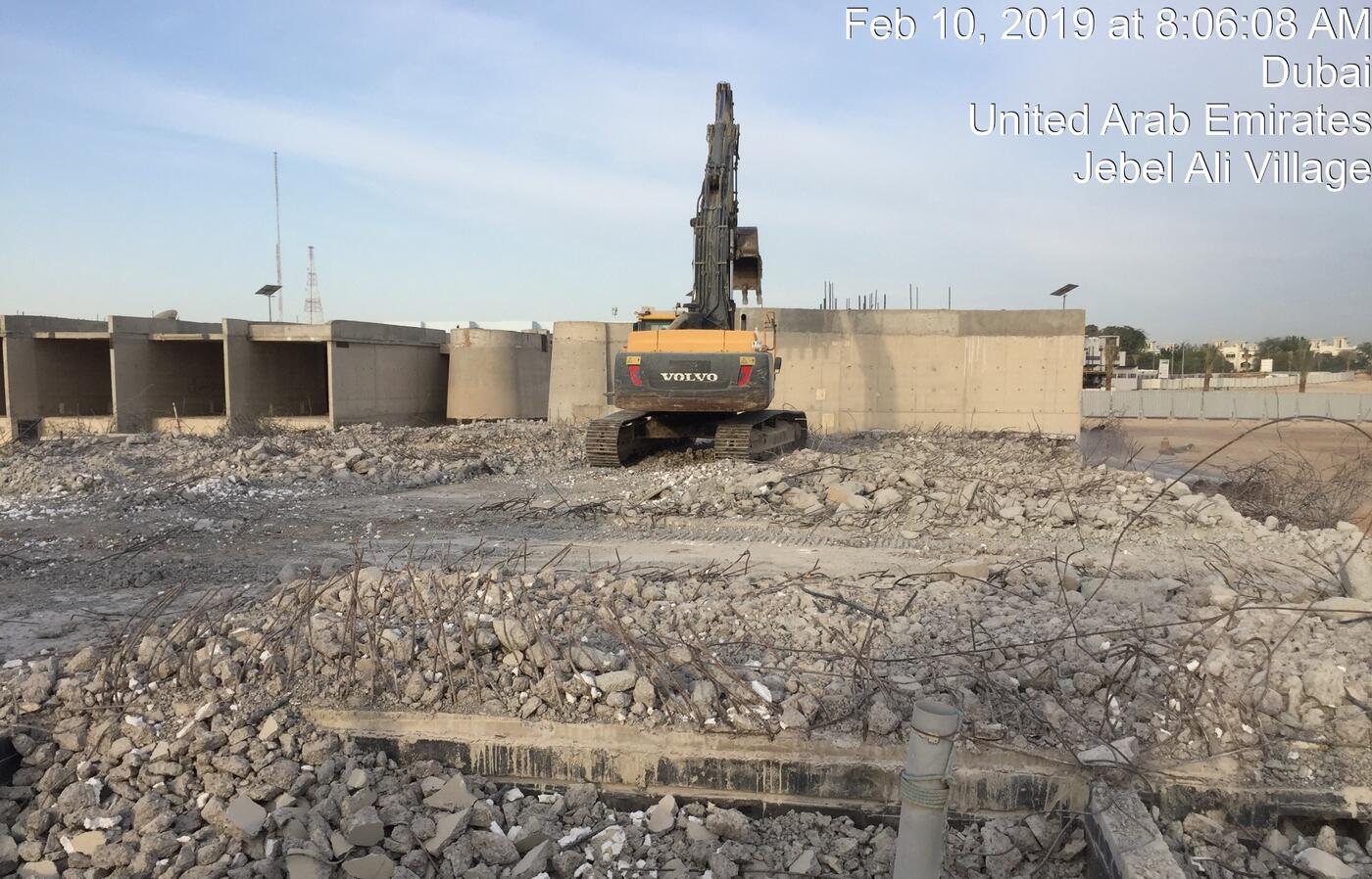 Volvo excavator breaking concrete foundation walls