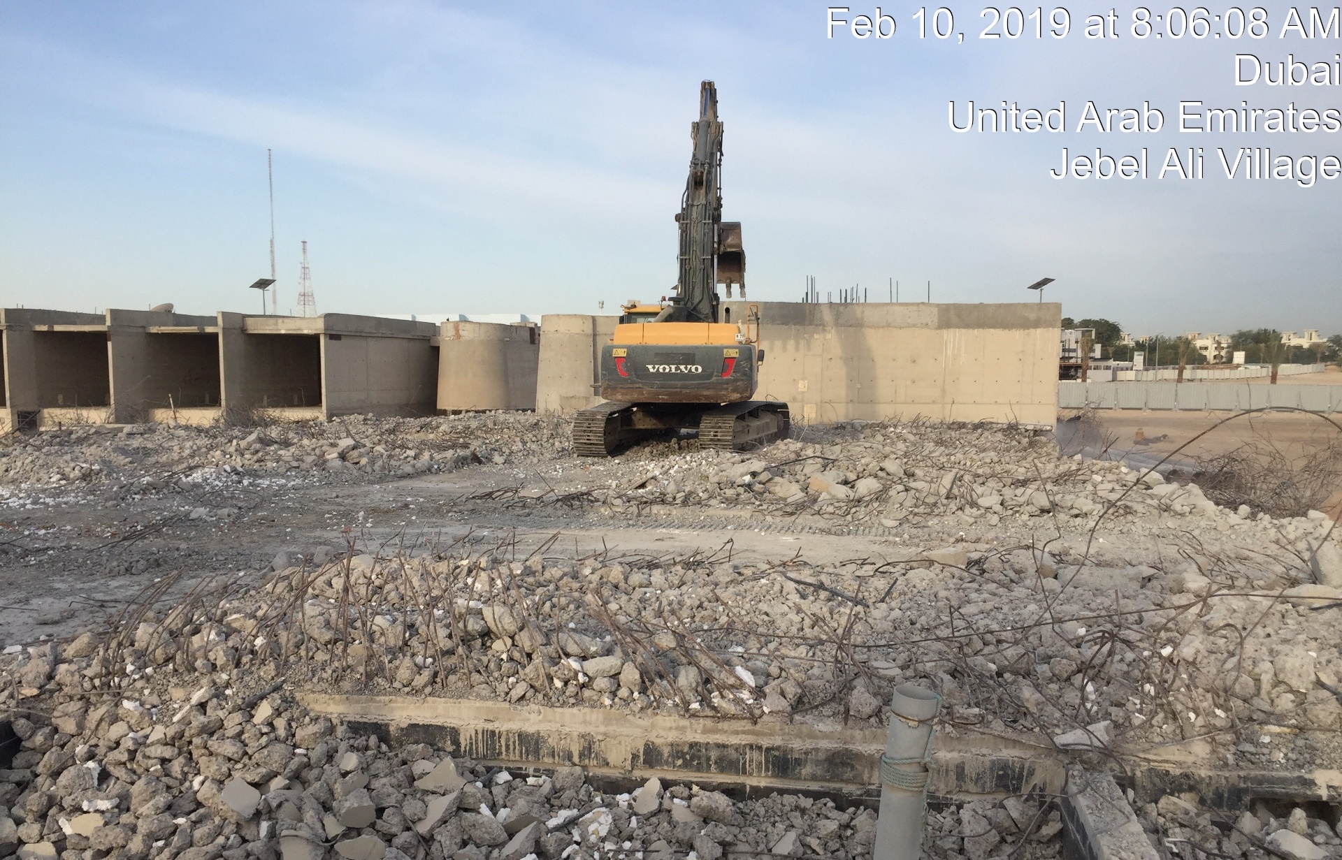 Volvo excavator breaking concrete foundation walls