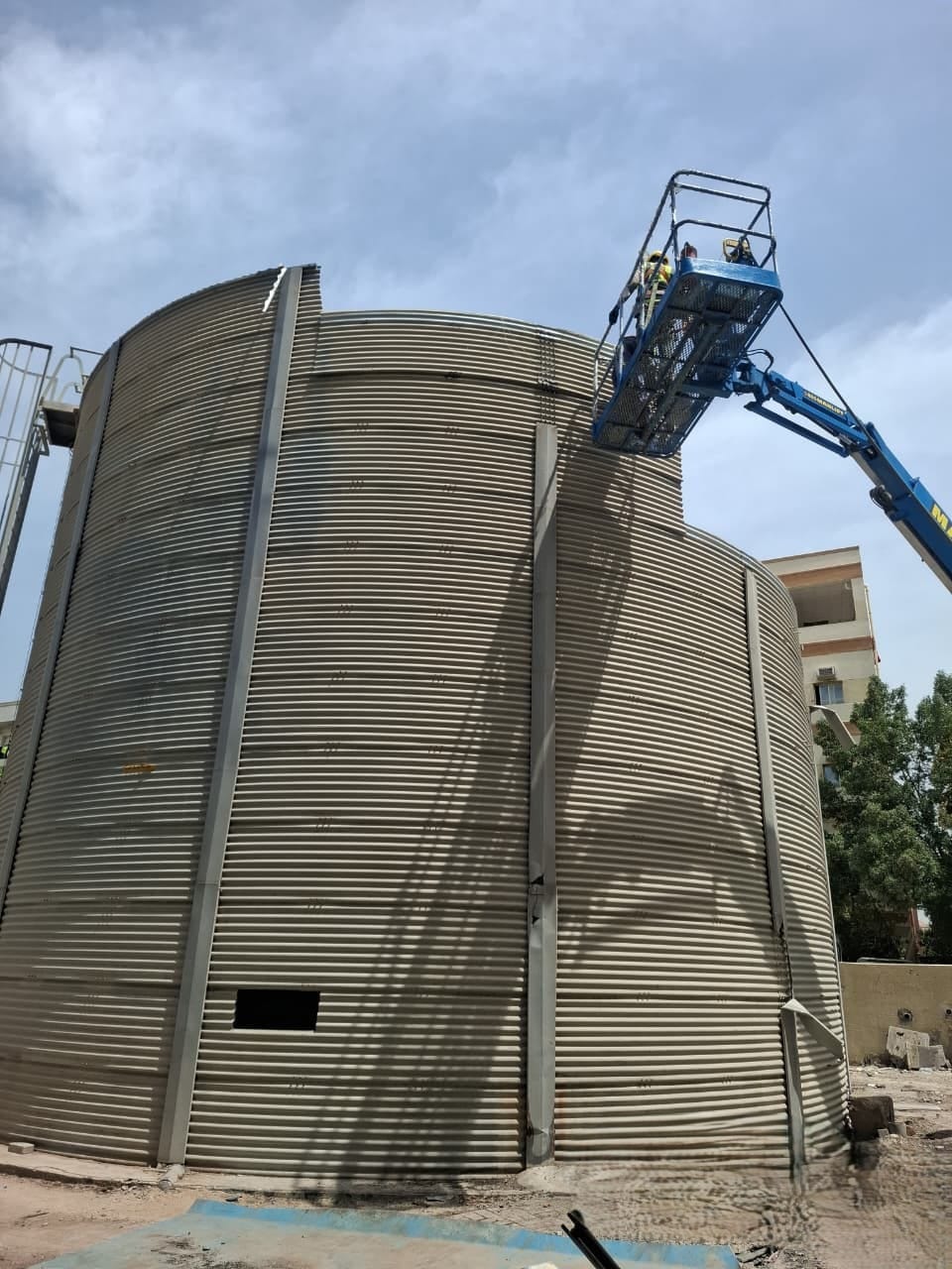 Boom lift operator dismantling upper section of sewerage treatment tank at Jebel Ali labour camp
