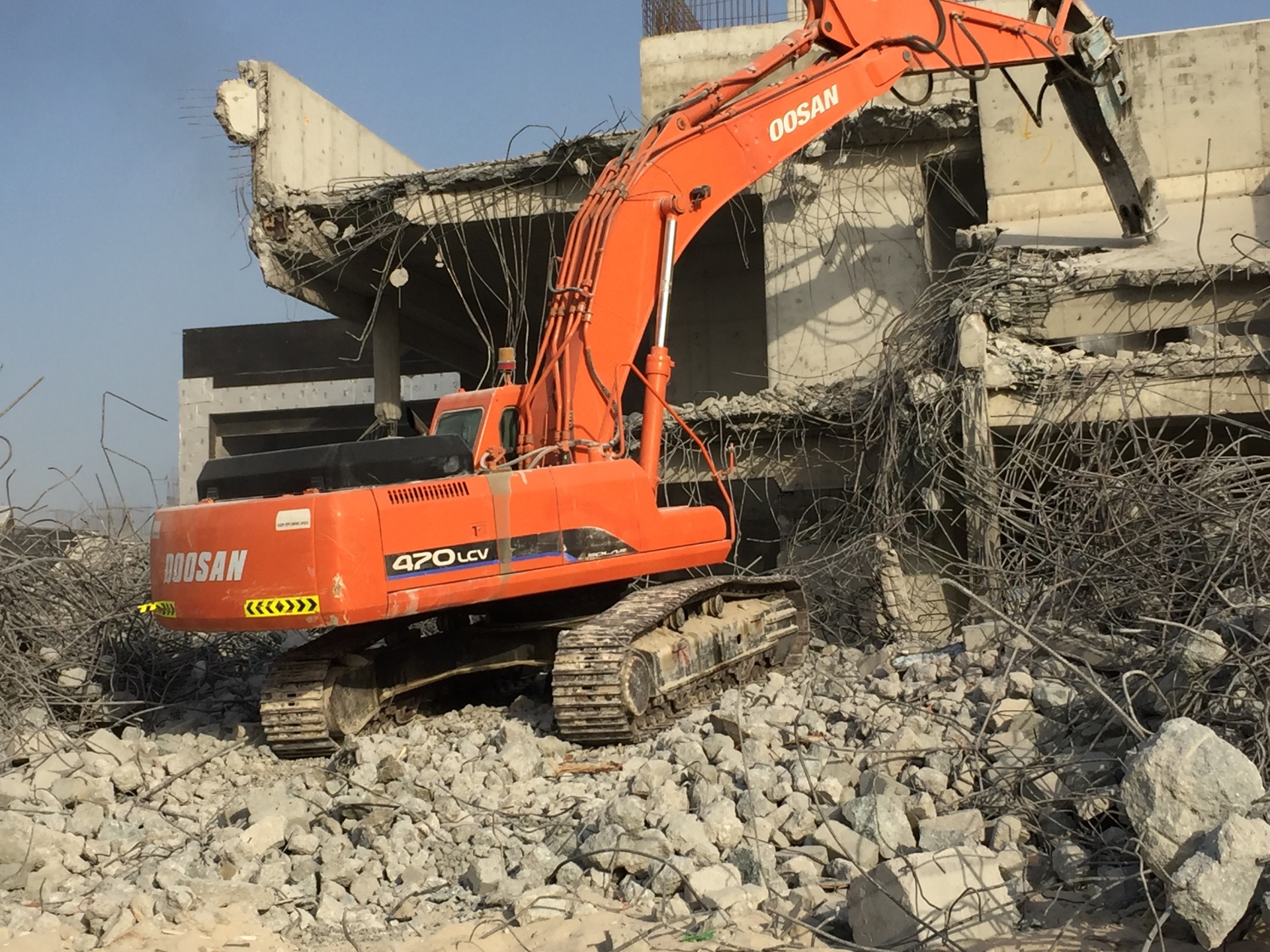 Doosan 470 excavator breaking concrete at luxury villa site
