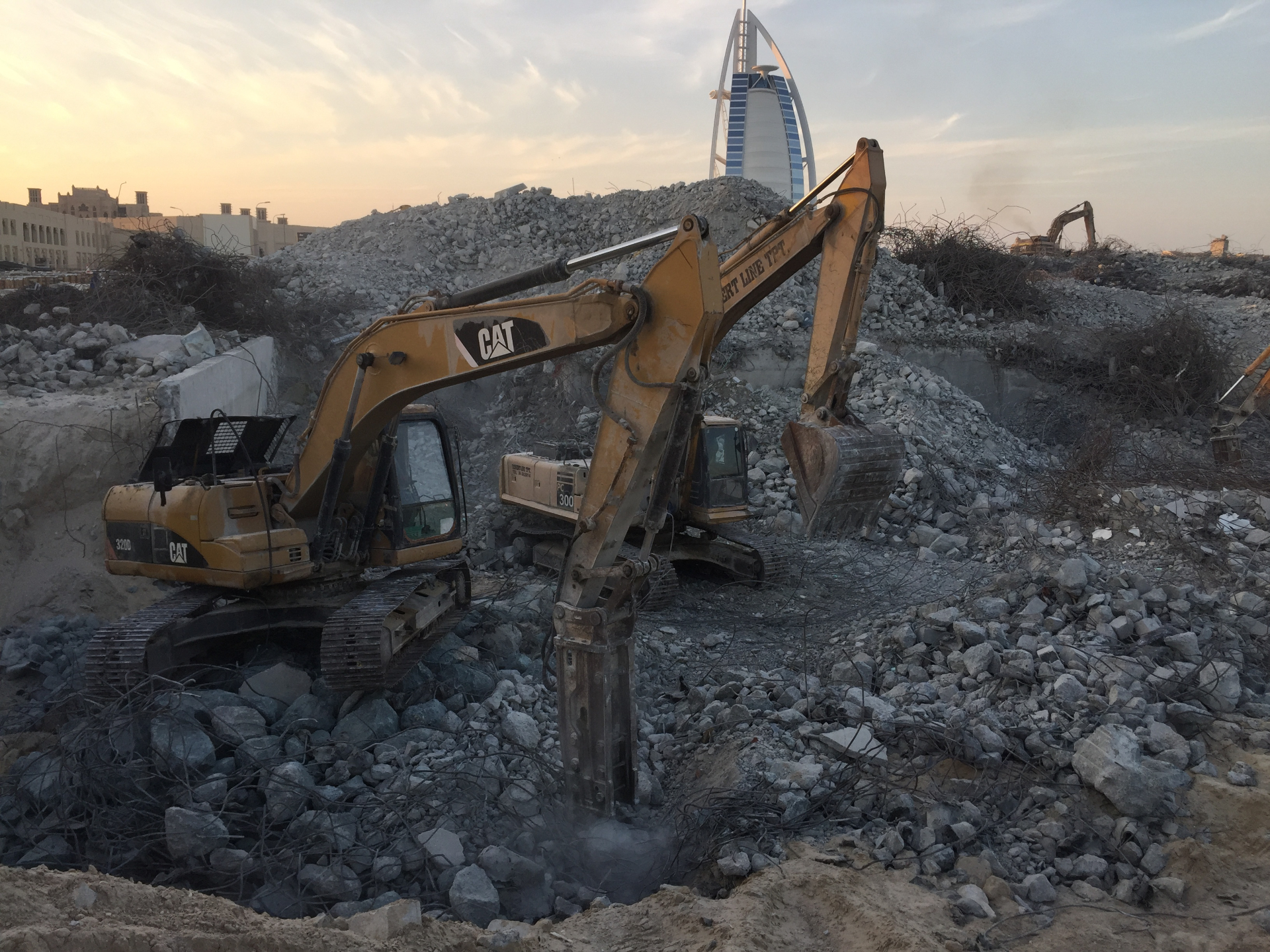 Two CAT excavators at villa demolition site near Burj Al Arab