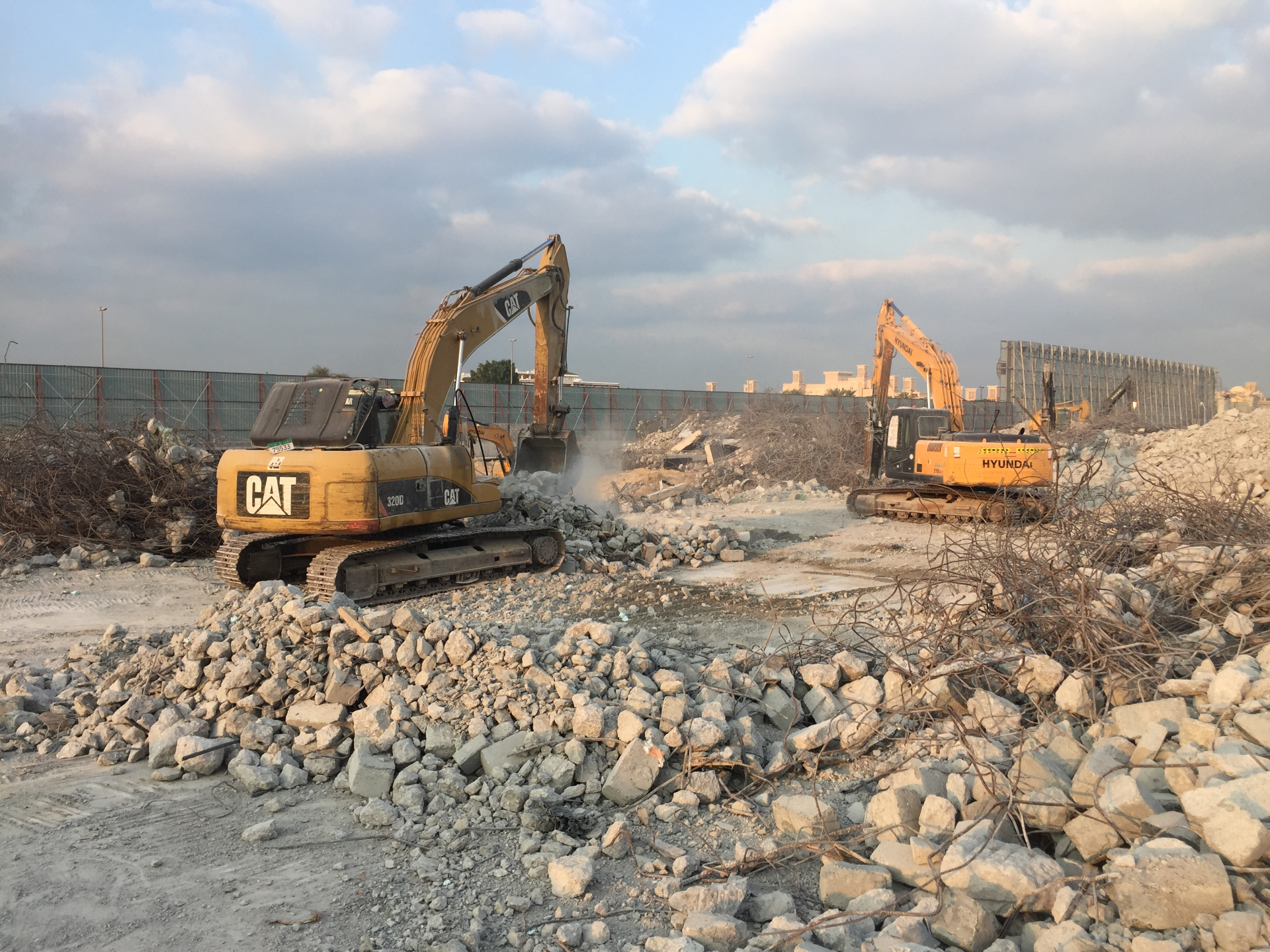 CAT and Hyundai excavators clearing debris at villa site