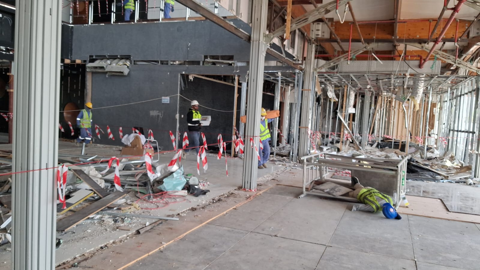 Wide view of emergency mock drill with safety barriers and personnel at demolition site