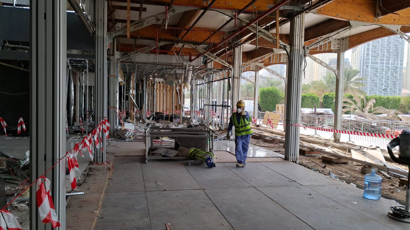 Worker approaching simulated casualty with safety barriers visible at demolition site
