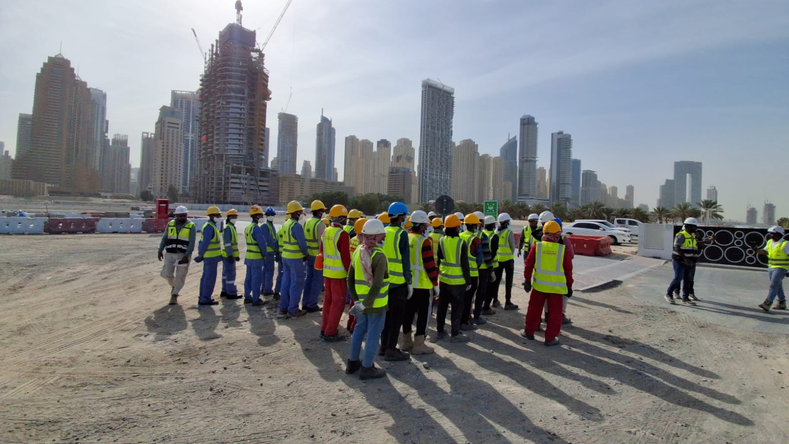 Mock drill assembly point with Dubai Marina skyline and construction workers