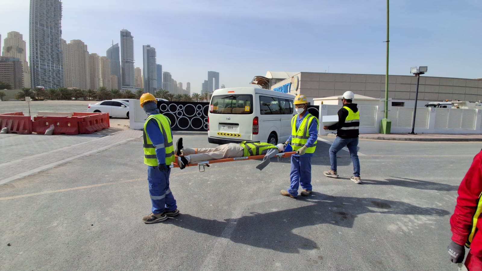 First responders carrying stretcher with simulated fall victim at construction site