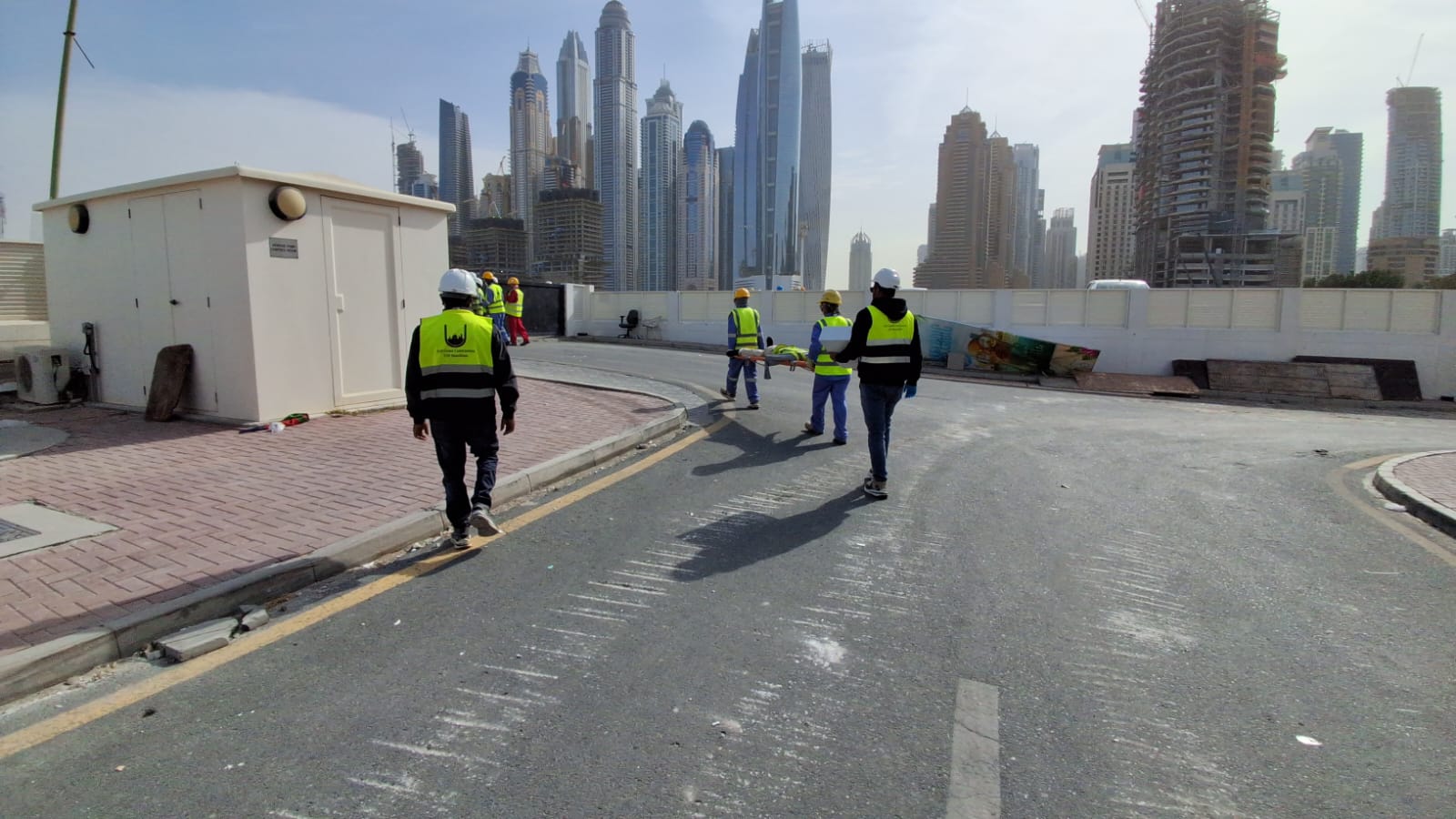 Safety team transporting casualty on stretcher with Dubai skyline background