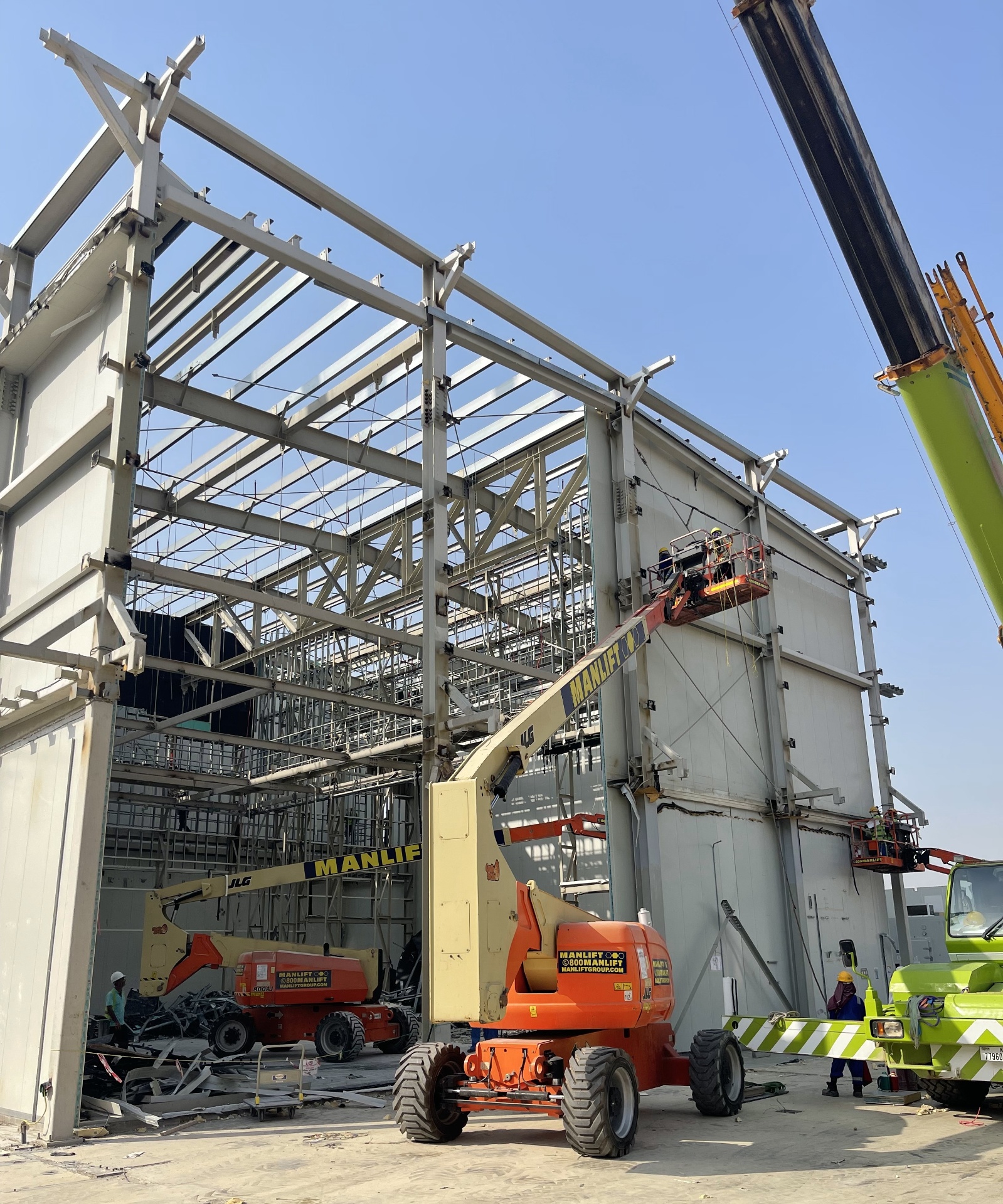 Manlift boom lifts inside exposed steel framework at New Zealand Pavilion