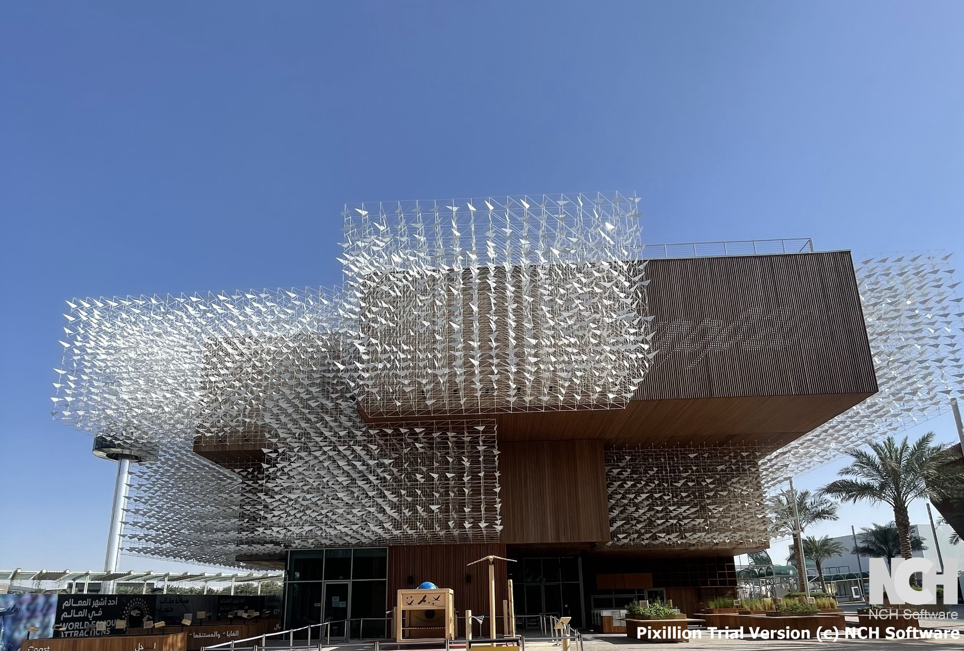Poland Pavilion front view with dramatic bird sculpture canopy and palm trees