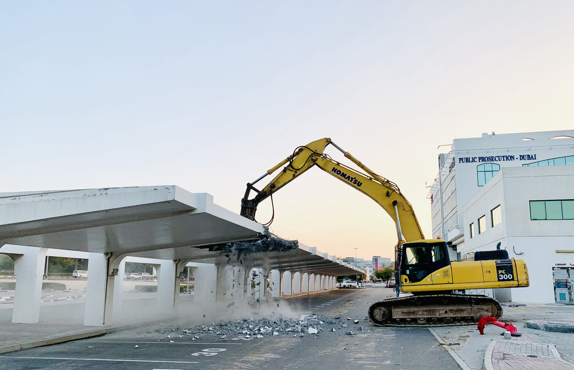 Komatsu PC300 excavator demolishing parking shade at Dubai Prosecution
