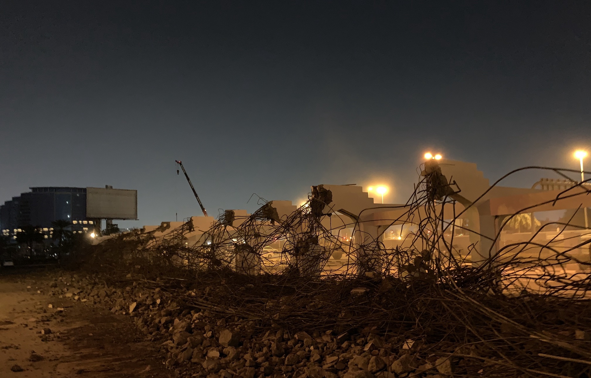 Night view of demolished parking structure with exposed rebar