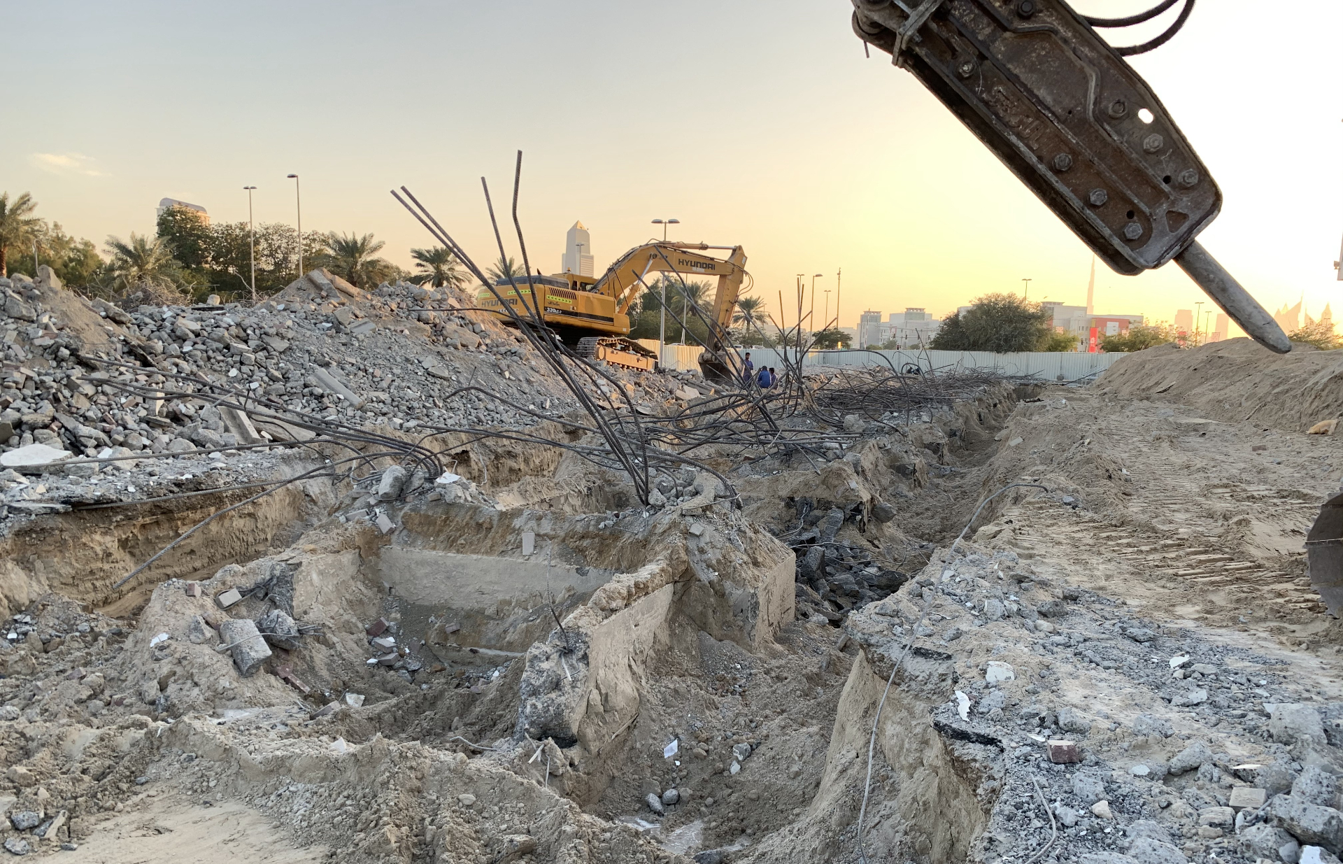Hyundai excavator at foundation removal with Dubai skyline