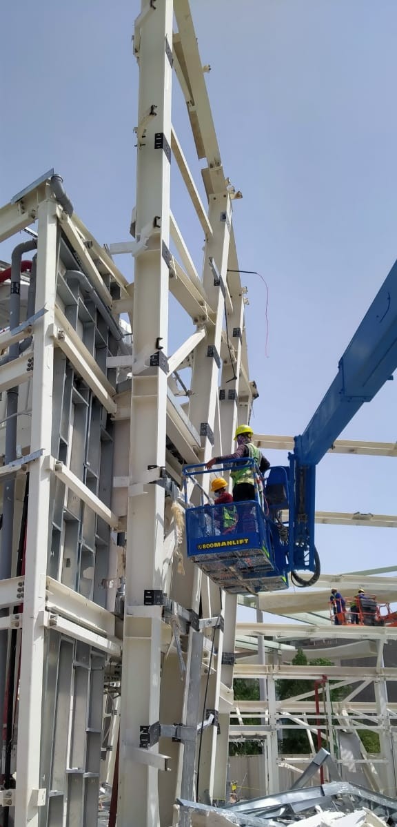 Boom lift worker dismantling steel framework at Qatar Pavilion