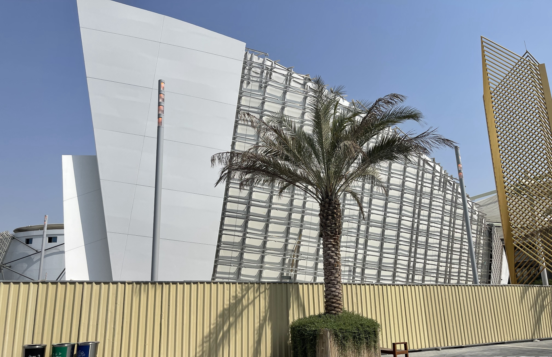 Qatar Pavilion exterior with exposed steel grid and palm tree