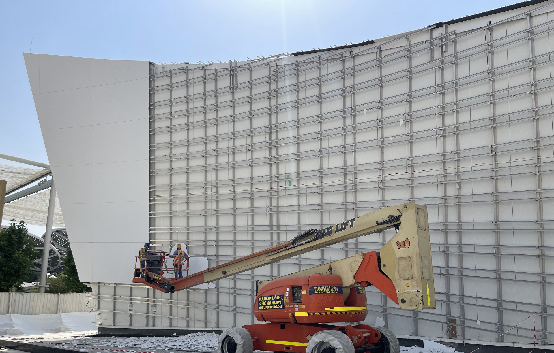 JLG lift workers removing facade cladding at Qatar Pavilion