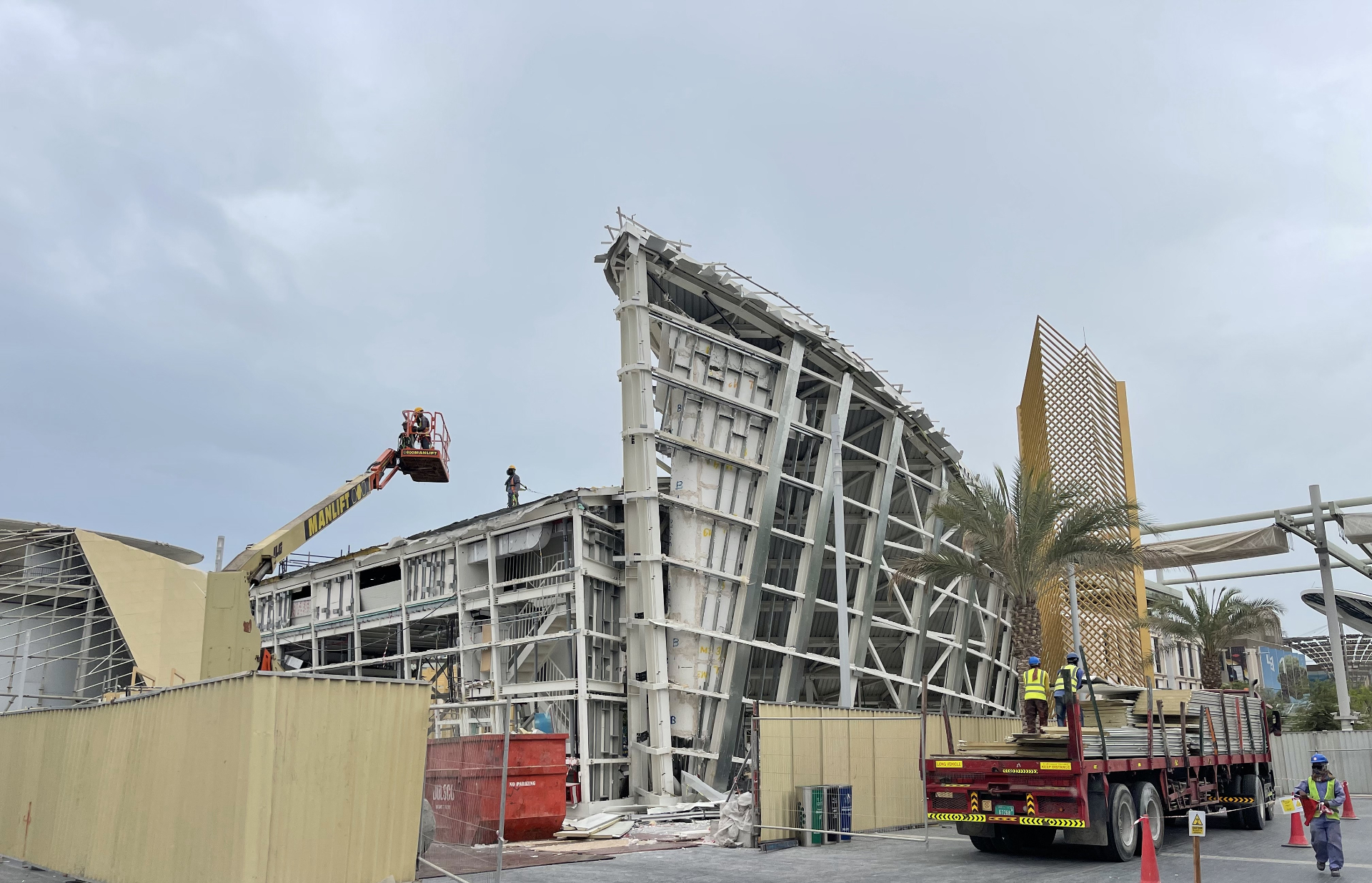 Manlift boom lift dismantling curved steel structure at Qatar Pavilion