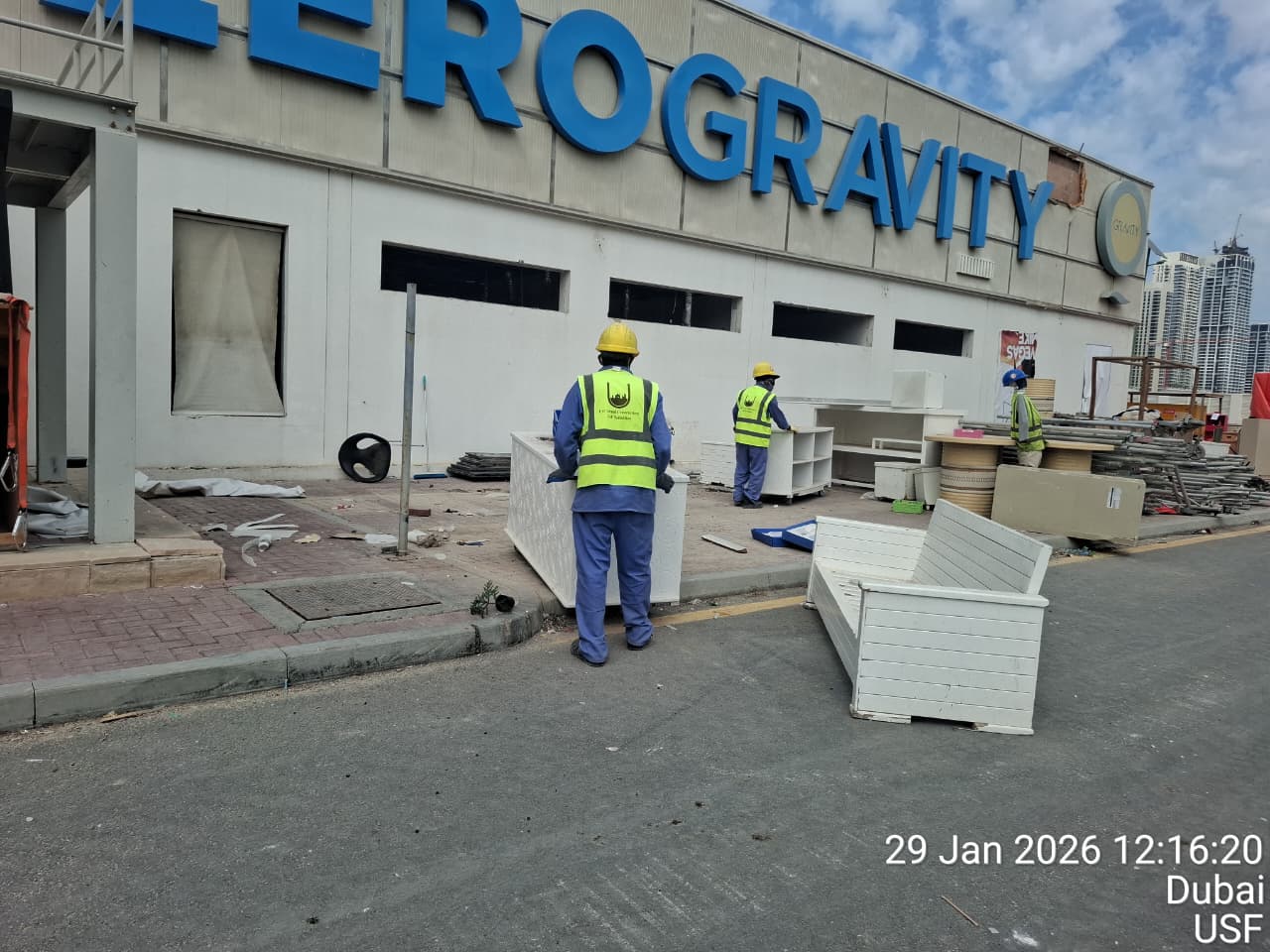 USF workers in safety gear at Zero Gravity entrance during active demolition