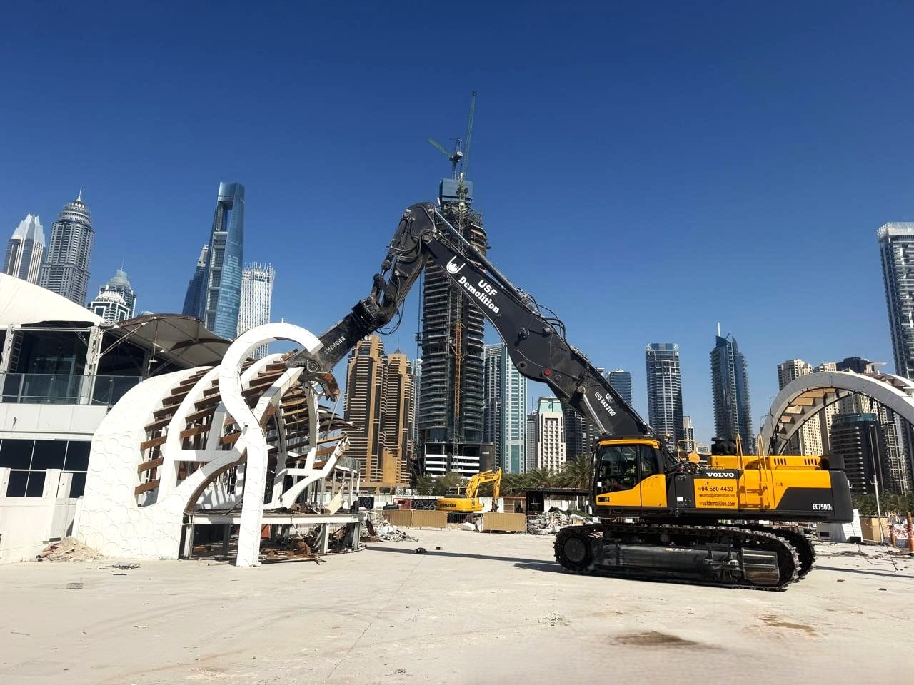 USF Demolition Volvo EC750D long-reach excavator dismantling tensile-canopy architectural feature at Zero Gravity Dubai Marina